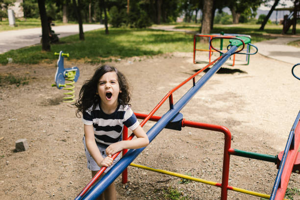 Young girl playing on monkey bars in a park