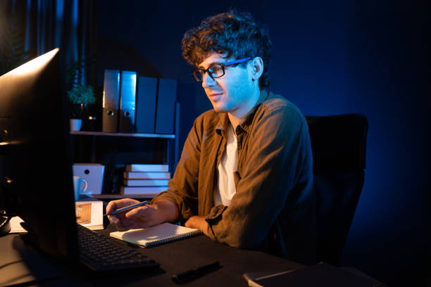 istock Businessman concentrating on pc on project at neon light office. Gusher. 2163668260