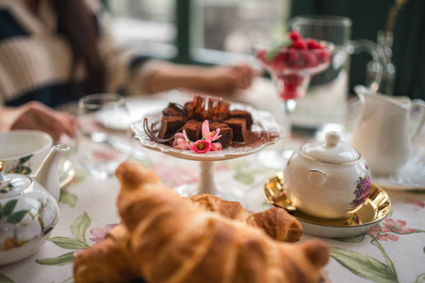 cup of coffee with dessert and roses on table