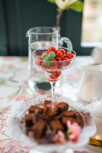 A gourmet breakfast featuring fresh raspberries in a clear glass and chocolate waffles, served with style in a boutique hotel's cozy restaurant.
