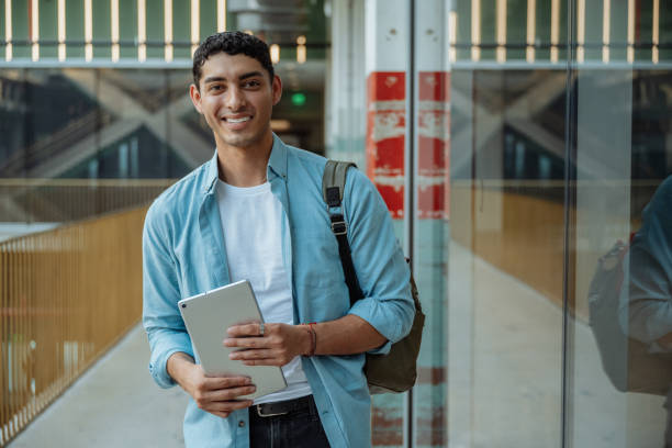 istock Hispanic student in the city holding digital tablet and smiling 2163669574