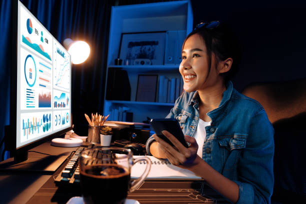 istock Smiling Asian creative looking pc of report and writing on notebook. Stratagem. 2163670033