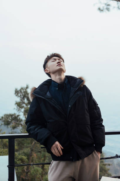 istock A man leaning against a railing in winter, feeling nature 2163670203