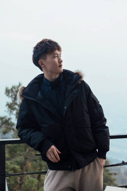 istock A man leaning against a railing in winter, feeling nature 2163670291