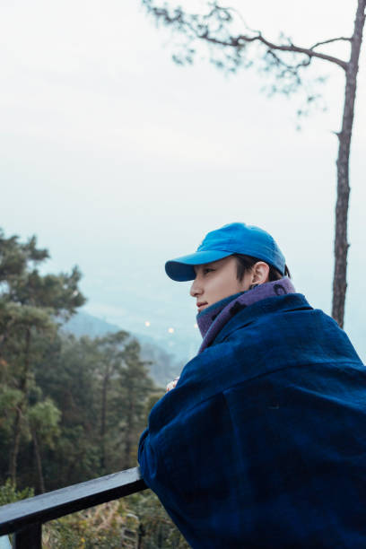 istock A man leaning against a railing in winter, feeling nature 2163670386