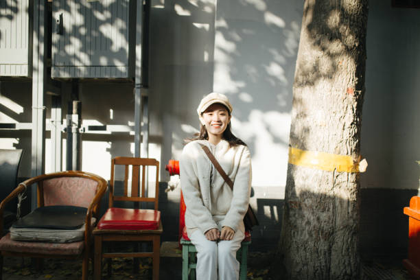 A beautiful woman is playing in a hutong in Beijing