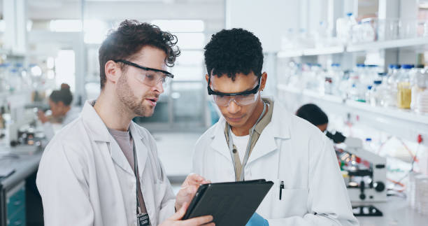 istock Tablet, team and scientists in laboratory with research for pharmaceutical innovation experiment. Collaboration, discussion and male medical science students on digital technology for biology data. 2163671946