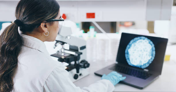 istock Woman, scientist and laptop with microscope in lab, microbiology and research study of organisms. Specimen, analysis and bacteria or antimicrobial resistance, digital imaging and vaccine development 2163672019