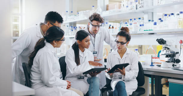 istock Tablet, science team and people learning for cancer cure, help or medical development in laboratory. Training, investigation or research info with scientists in clinical trial for medicine internship 2163672034