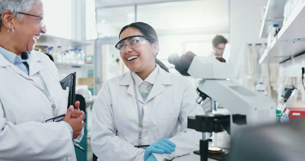 istock Women, laboratory and happy for science talk with technology for research, teamwork or support for pharma. Female leader, scientist or collaboration with mentor for medical innovation or breakthrough 2163672055