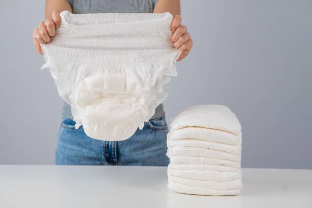 A woman chooses an adult diaper from a pile. Urinary incontinence problem. A woman chooses an adult diaper from a pile. Urinary incontinence problem adult diaper senior stock pictures, royalty-free photos & images