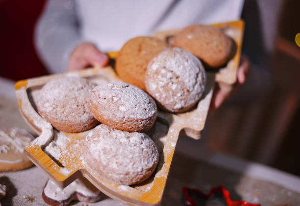 Hands hold cookies on a plate in the shape of a Christmas tree