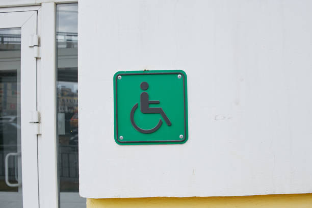 A green parking sign for the disabled on the wall of the house.