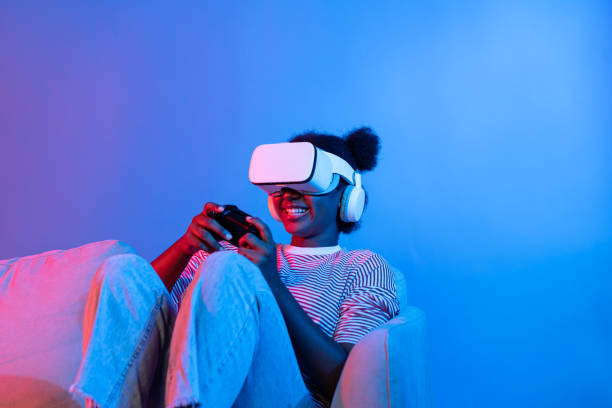 istock Smiling African playing gaming player wearing VR control joystick. Contrivance. 2163680940