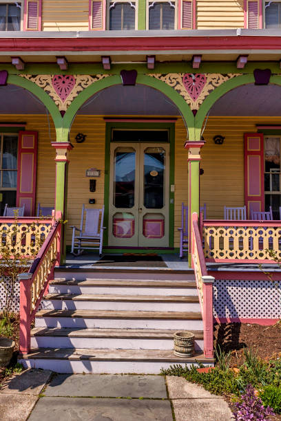 This inviting and cheerful porch is an example of the kind of colorful Queen Anne Victorian architecture typical of Cape May. \n\nCape May, New Jersey, is a historic seaside city known for its beautiful beaches, charming Victorian architecture, and vibrant cultural scene. It is one of the oldest vacation resort destinations in the United States, with its origins dating back to the 18th century. Cape May is renowned for its picturesque Victorian houses and buildings, featuring ornate details, colorful facades, and intricate woodwork.