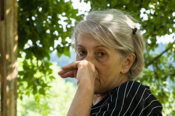 istock Senior sad woman is sitting alone outside 2163681260