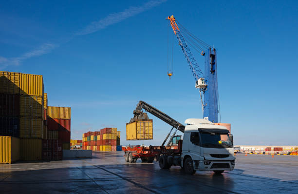 A top handler and a utility tractor rig in an intermodal shipping yard in the Port of Long Beach, California.