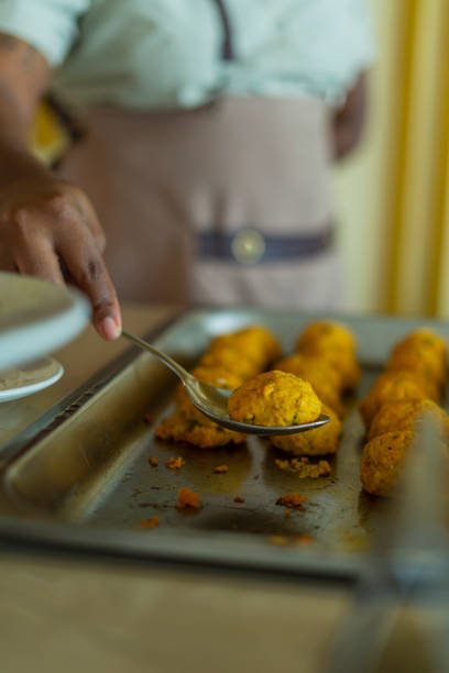 chef's hands serving tuna balls from buffet lunch in hotel