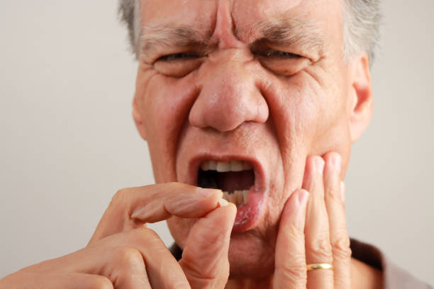 istock Man holding up his chipped tooth between his fingers. 2163685143