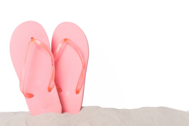 Flip flops on sand against isolated background