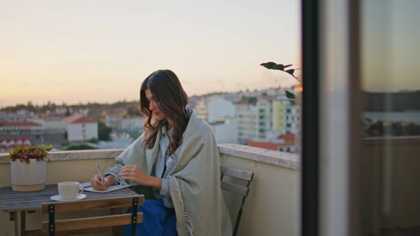 Romantic brunette writing notebook resting evening balcony closeup. Woman author