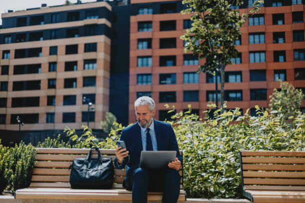 Businessman Working Outdoors with Laptop and Phone