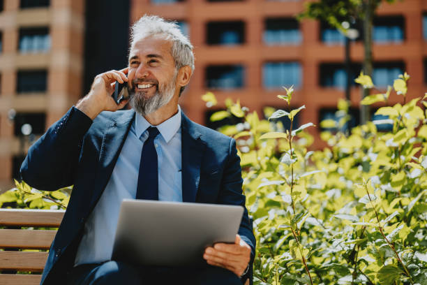 istock Happy Businessman Working Outdoors on Phone and Laptop 2163692178