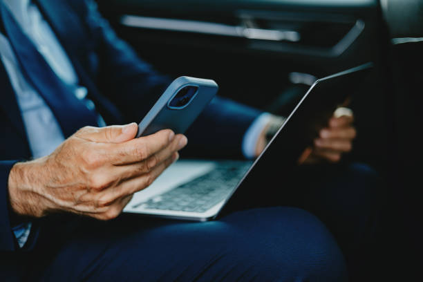 istock Businessman Using Smartphone And Laptop In Car 2163692182