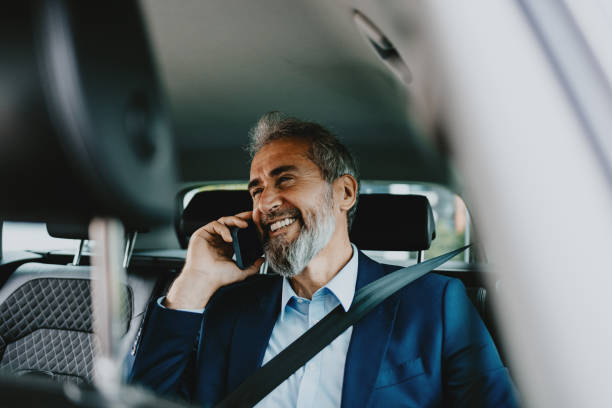 istock Happy Businessman Talking on Phone While Driving in Car 2163692186