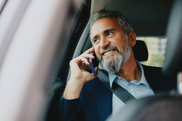 istock Smiling Businessman Talking on Cell Phone in Car 2163692217