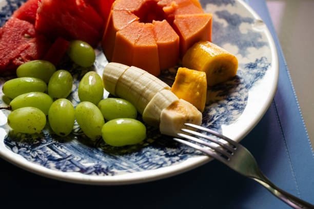 Papaya watermelon grape and bananas inside a plate. Breakfast. healthy eating. Fruits.