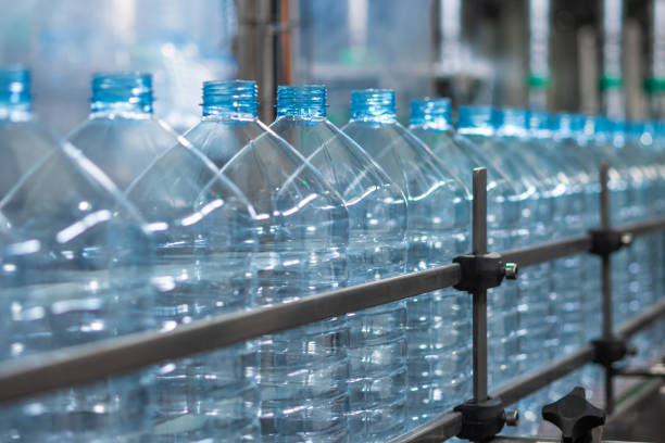 istock Empty blue five-liter plastic bottles on a conveyor belt. Automated production of drinking water 2163698139