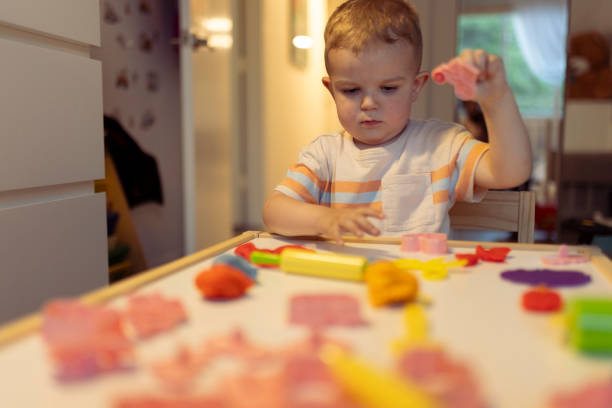 istock Sweet little boy playing and creating from modeling clay or plasticine 2163698300