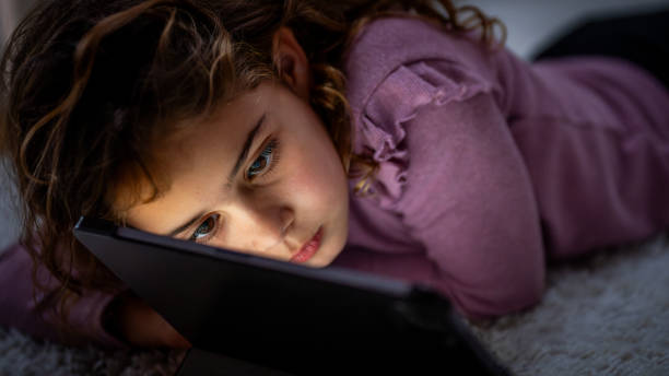 istock Engrossed Young Girl with Tablet on Cozy Floor 2163698466