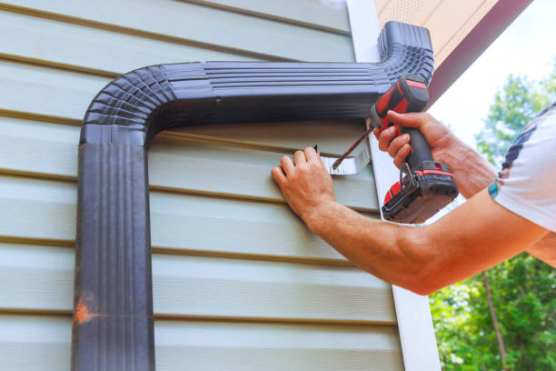 istock Worker installing rain gutters on roof, fitting downpipes, a installing downspout bends 2163700017