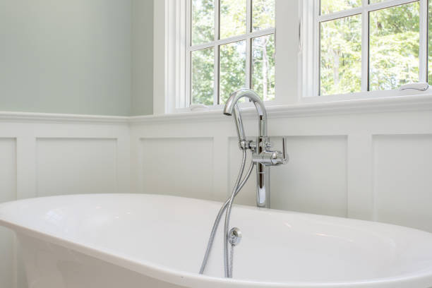 istock Modern Bathroom With A White Freestanding Bathtub Under Large Bright Windows. 2163702915