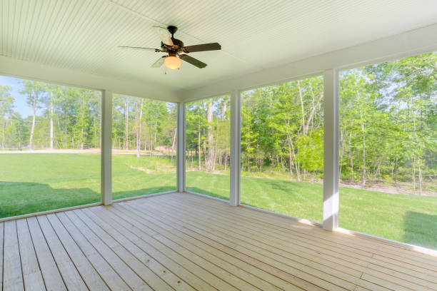 istock Spacious Screened-In Porch With Ceiling Fan Overlooking Lush Backyard Greenery. 2163703087