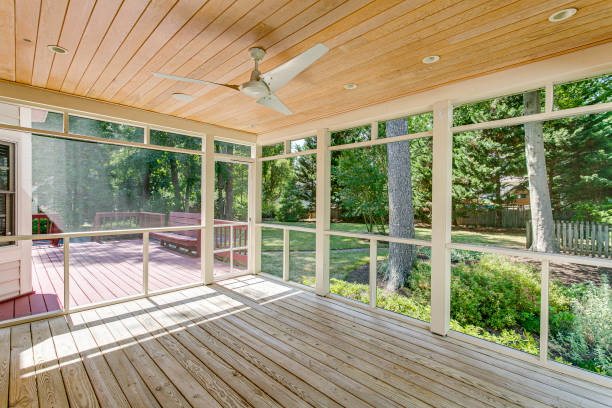 Spacious Screened-In Porch With Ceiling Fan And Deck Overlooking Green Backyard.