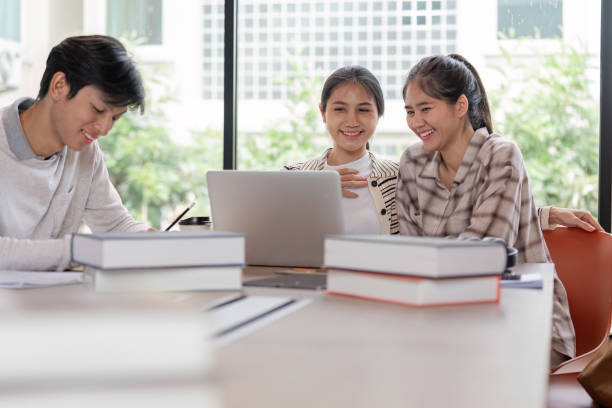 istock Group of Happy Students Studying Together with Laptops and Books in a Bright Modern Classroom 2163710110