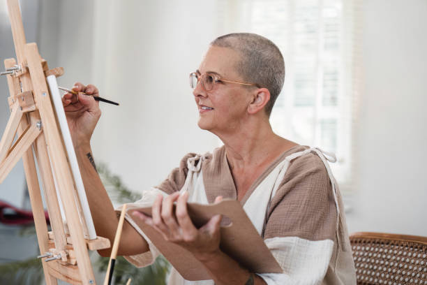 istock Senior Woman Painting on Canvas in Bright Studio with Natural Light and Artistic Tools 2163710285