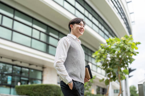 istock Confident Young Professional Walking Outside Modern Office Building with Tablet in Hand 2163711193