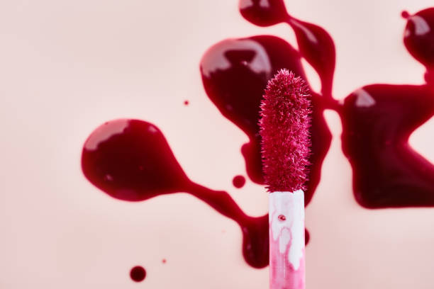 Tint lip gloss brush close-up and abstract sample drops, vertical format
