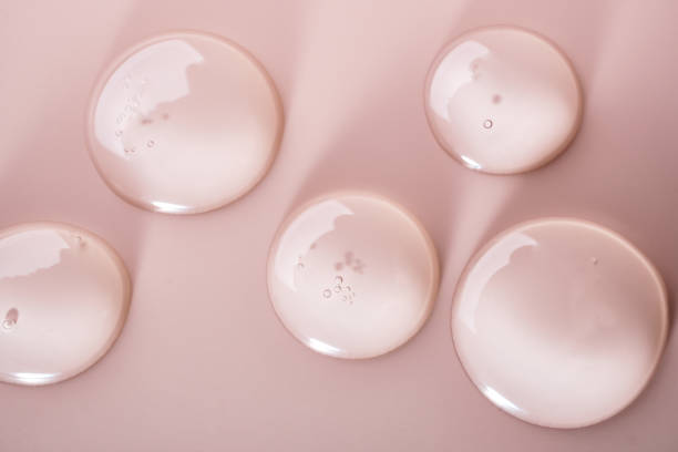 istock Cosmetic transparent gel drops texture on pastel pink background 2163718398