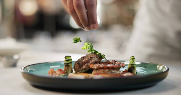istock Hands, food or sprinkle on dish for fine dining, culinary school or luxury restaurant. Chef, healthy protein or spices on plate for seasoning, catering and hospitality for event in commercial kitchen 2163721152