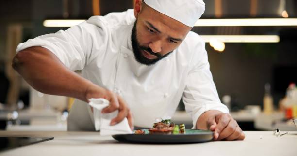 istock Man, chef and serious with plate in kitchen at restaurant for fine dining, meal and creativity. Male employee, professional and cooker with food for culinary, hospitality and catering service 2163721160