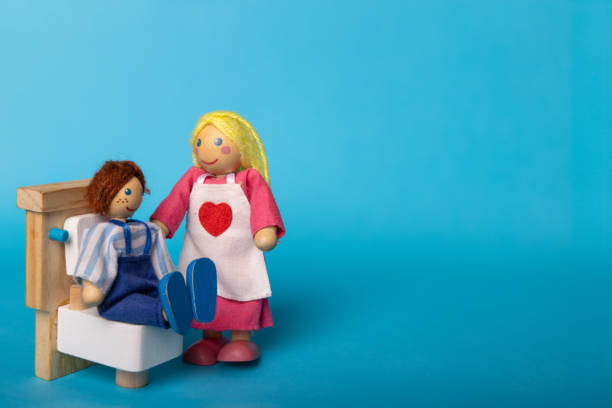 Wooden toys depicting a mother assisting her child during bath time, set against a blue background. A playful and educational scene