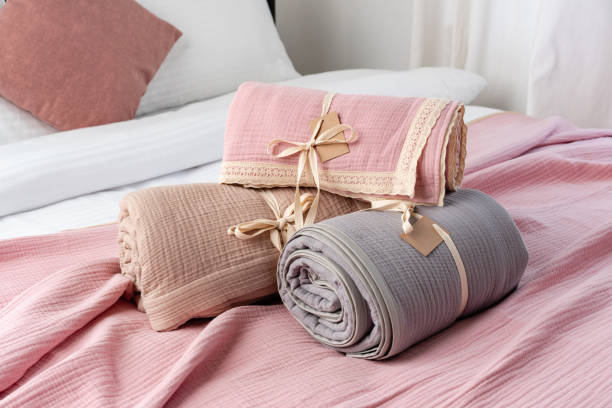 istock Rolled Up Soft Pink and Grey Muslin Blankets on Bed 2163725496