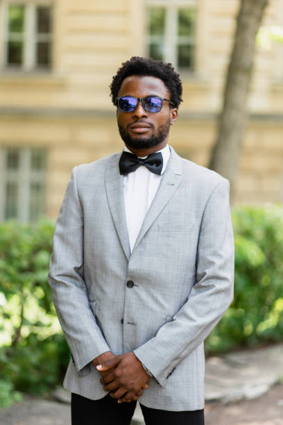 A striking portrait of a handsome Afro-American man wearing eyeglasses. His confident and stylish appearance highlights his sophistication and charm