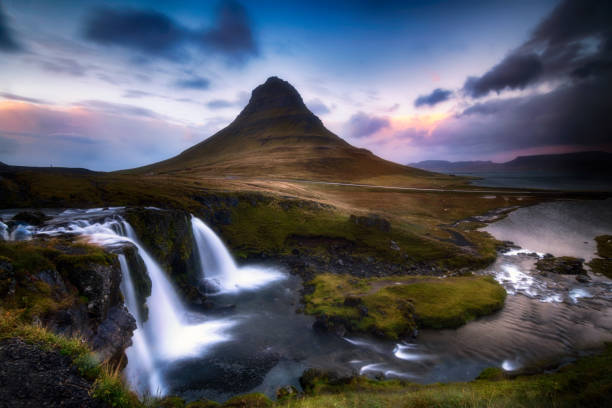 Kirkjuffel is a mountain of volcanic origin located in Grundarfjörður, on the Snæfellsnes peninsula, west of Iceland. At 463 meters high, Kirkjufell mountain is one of the essential places to see in Snaefellsnes. Its location on the seashore and its curious, almost perfect conical shape have made Kirkjufell, “the church mountain”, the most photographed landscape in Iceland. peninsula stock pictures, royalty-free photos & images