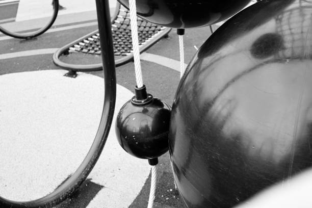Manchester, UK - September 30, 2025: Abstract stainless steel sculpture in a public park near trees and office blocks in Manchester.